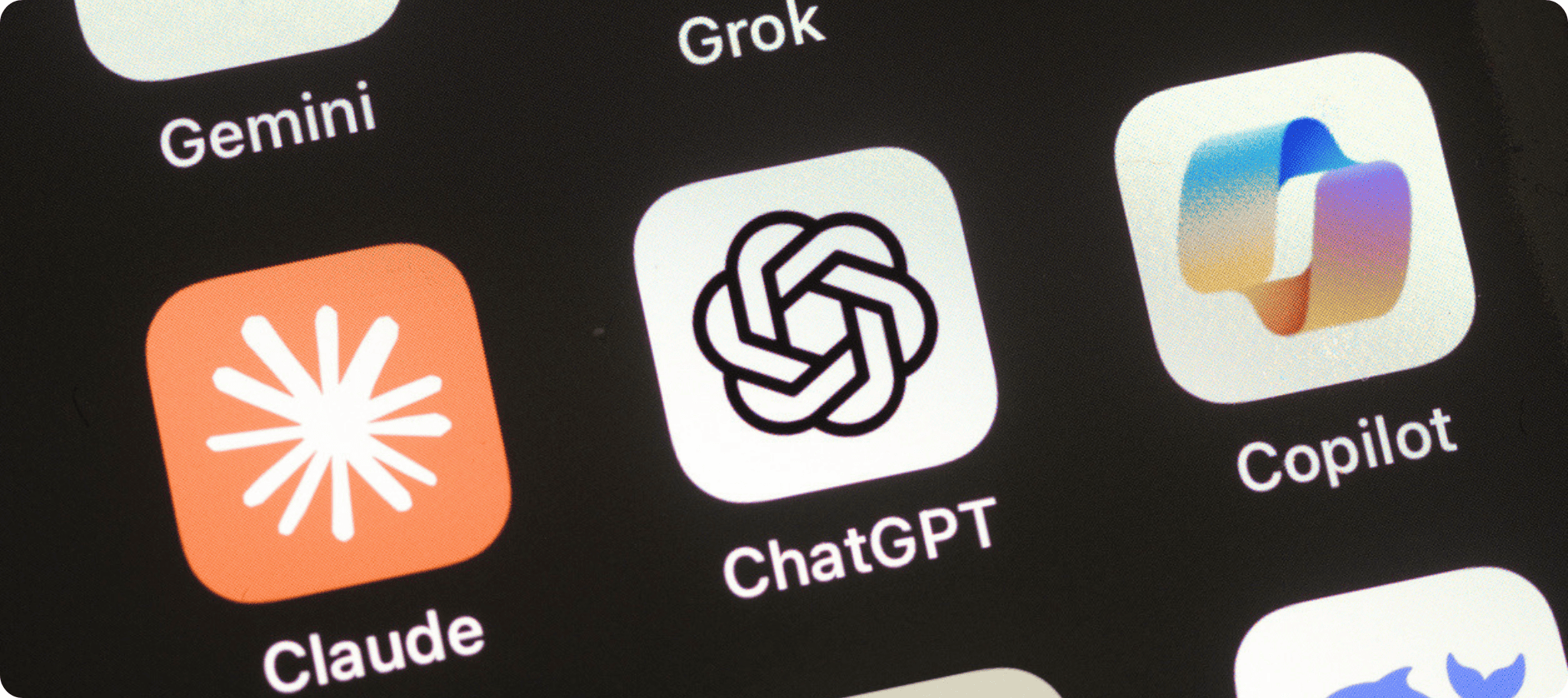 Close-up of a smartphone screen displaying AI app icons, including ChatGPT, Claude, Gemini, Grok, and Copilot.