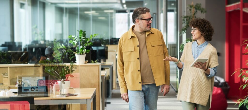 Quiet Hiring Blog Post Featured Image; Two coworkers walking in office conversing