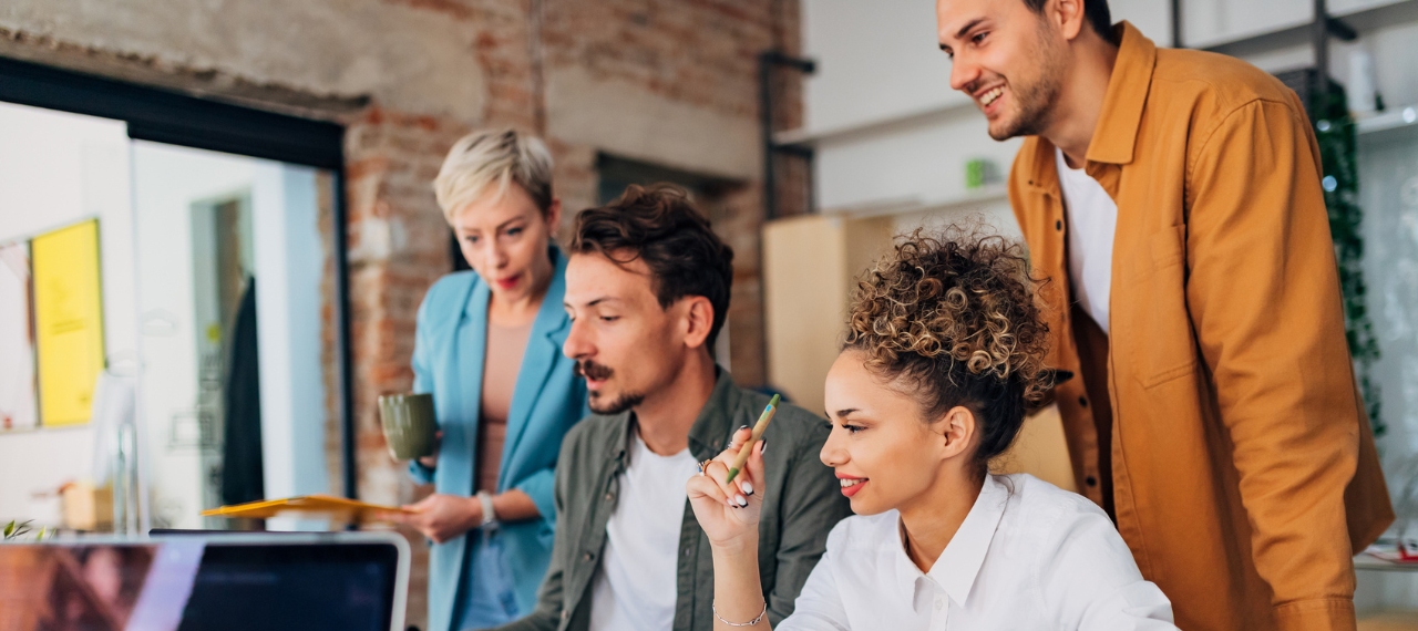 A high-performance team gathers around a computer to explore strategies for scaling