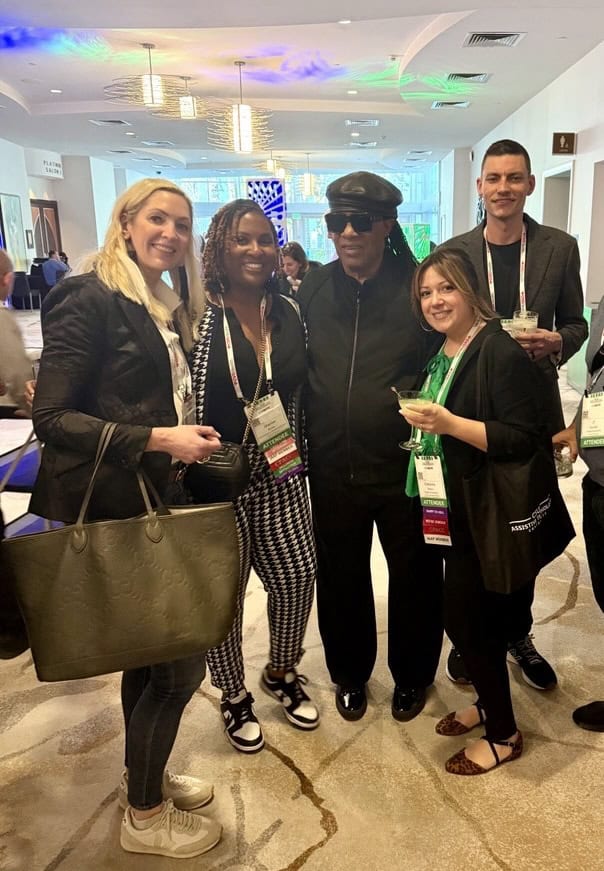 A group of Onward Accessibility team members pose together at an industry event with Stevie Wonder. The image reflects community, advocacy, collaboration, and Onward Accessibility’s active role in supporting inclusive practices.
