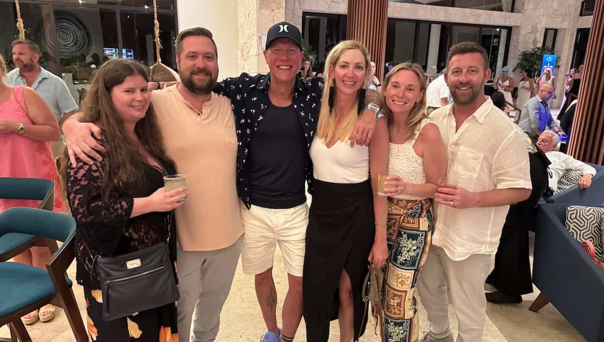 A group of Onward team members gather together at an evening company event, smiling and celebrating. The image reflects connection, belonging, recognition, and a workplace culture built on strong relationships.